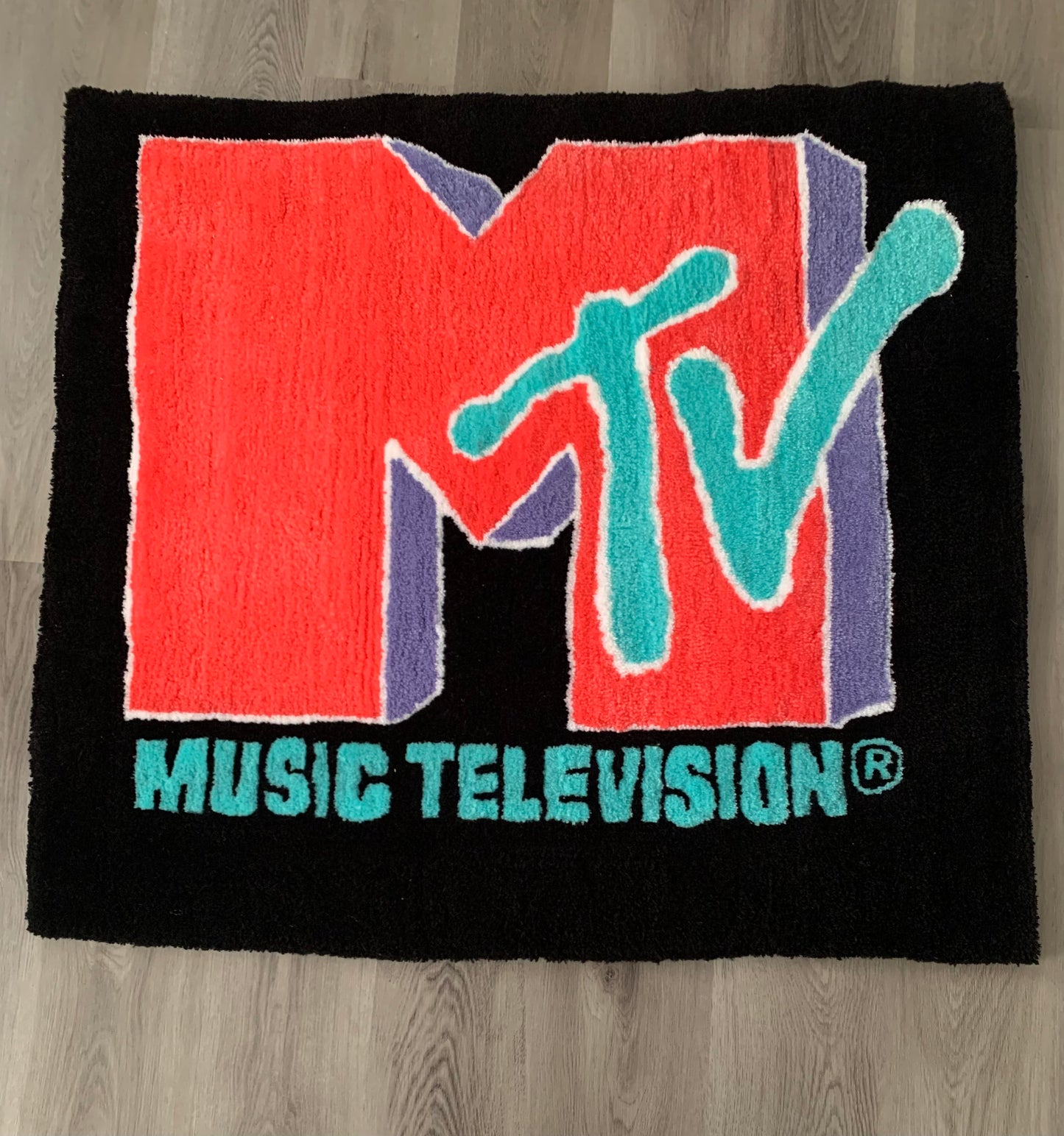 Custom-made tufted rug featuring a MTV design. Handcrafted with love, this unique piece adds an awesome touch to any space.