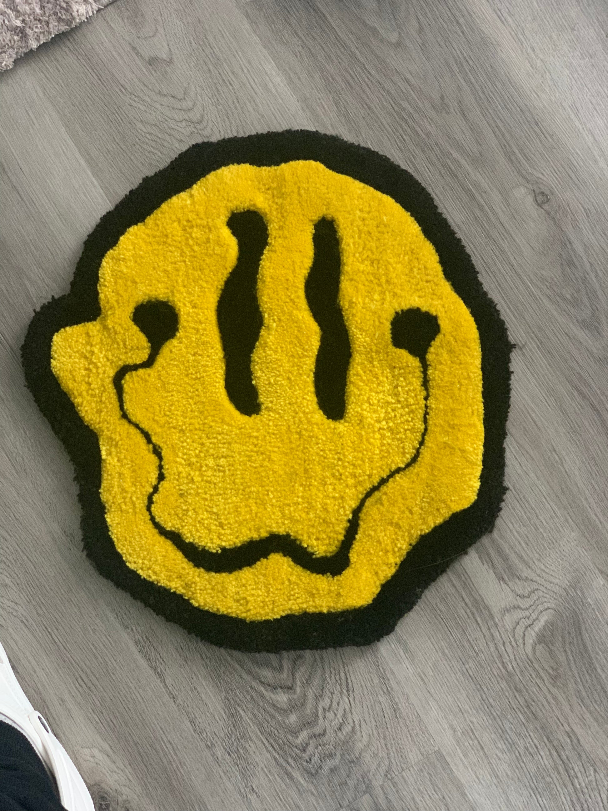 "Custom-made tufted rug featuring a charming smiley face design. Handcrafted with love, this unique piece adds a playful touch to any space."